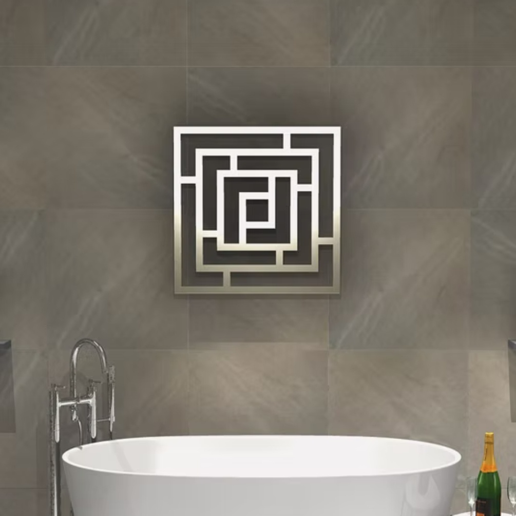 Lifestyle image of the Radox Maze 690mm x 690mm Stainless Steel Designer Heated Radiator mounted on a wall, above a freestanding bath & bath filler